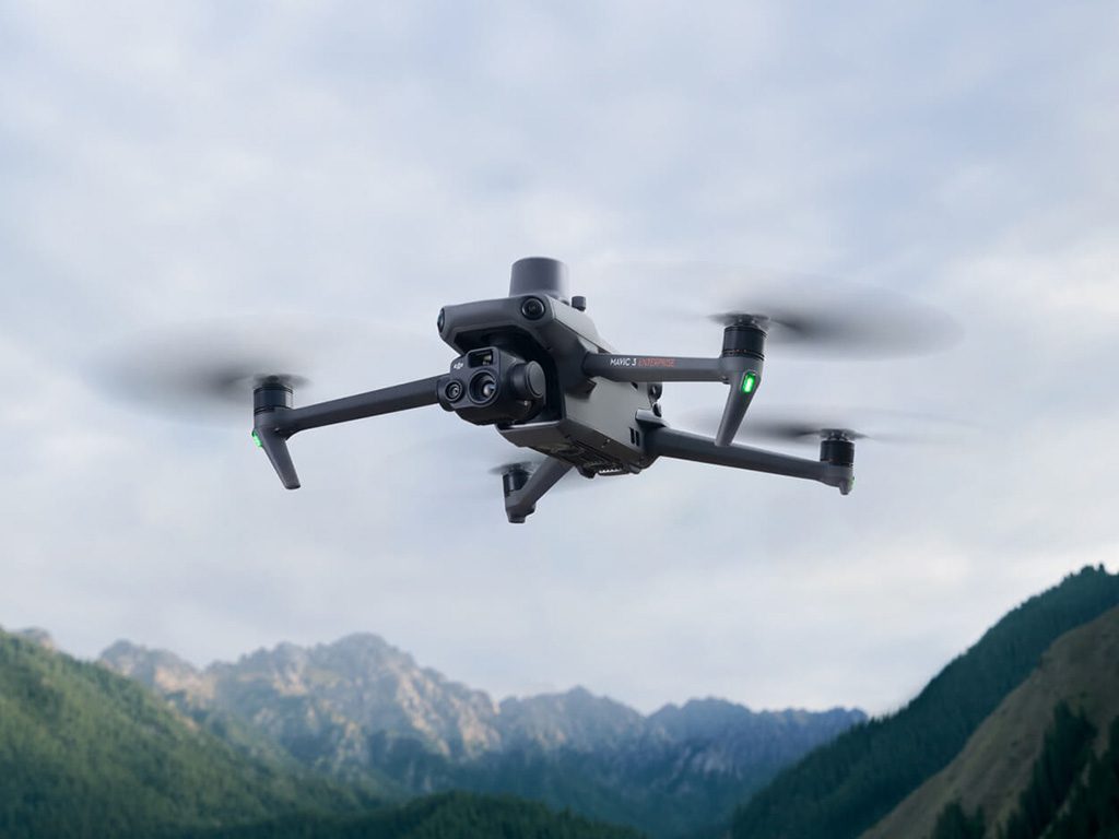 Drone DJI Mavic 3 en vol devant des montagnes, idéal pour la cartographie.